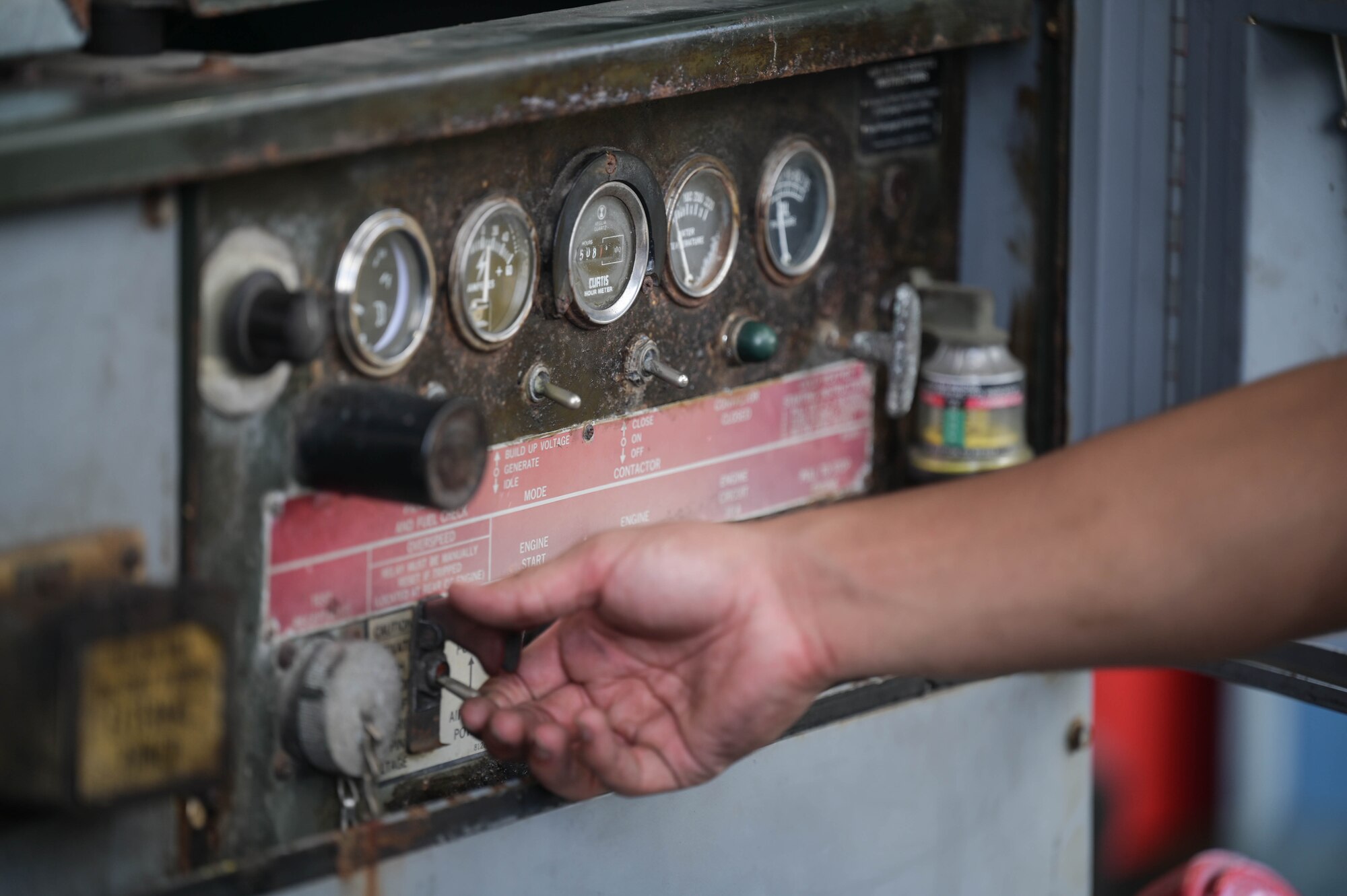 Airman flipping switches on a generator.
