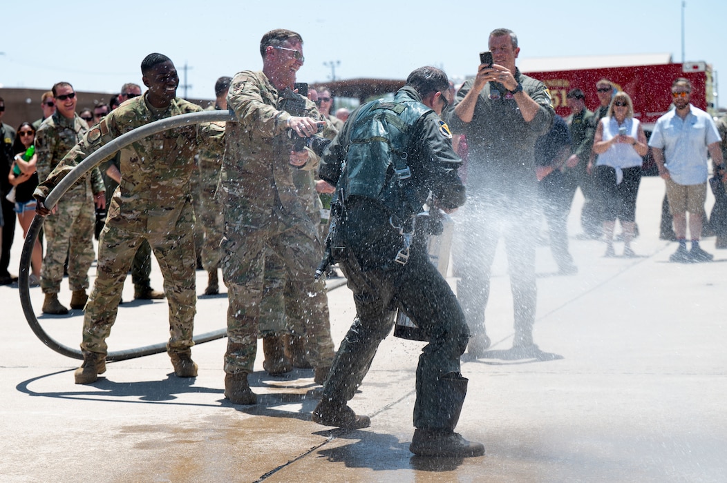 U.S. Air Force Col. Sean Hall, 355th Operations Group commander, is sprayed with water after his fini flight at Davis-Monthan Air Force Base, Arizona, June 30, 2025. The spray-down was a fini flight tradition in the military. (U.S. Air Force photo by Senior Airman Jasmyne Bridgers-Matos)