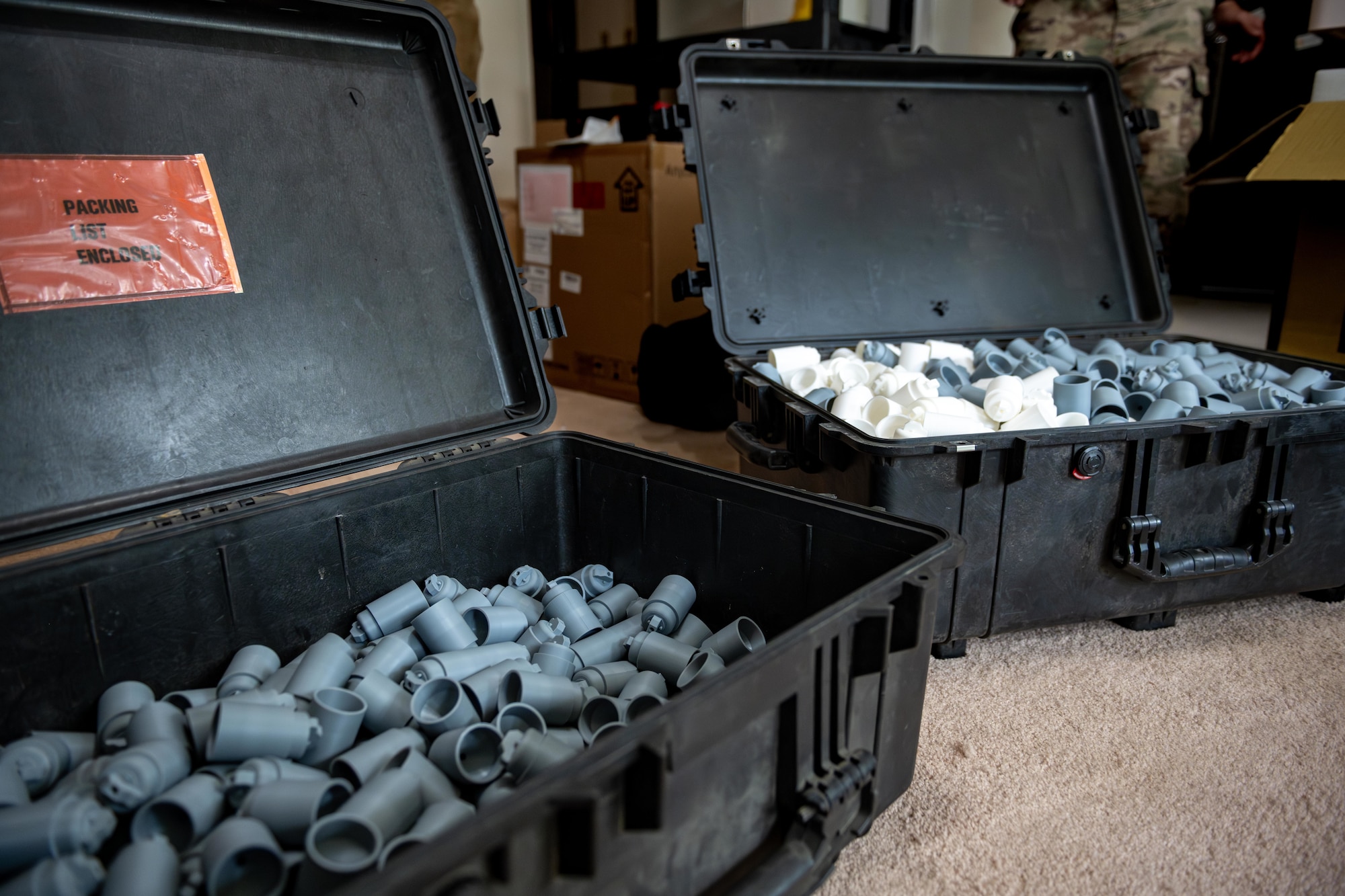 Two cases of 3D-printed training aid grenades sit open for counting.