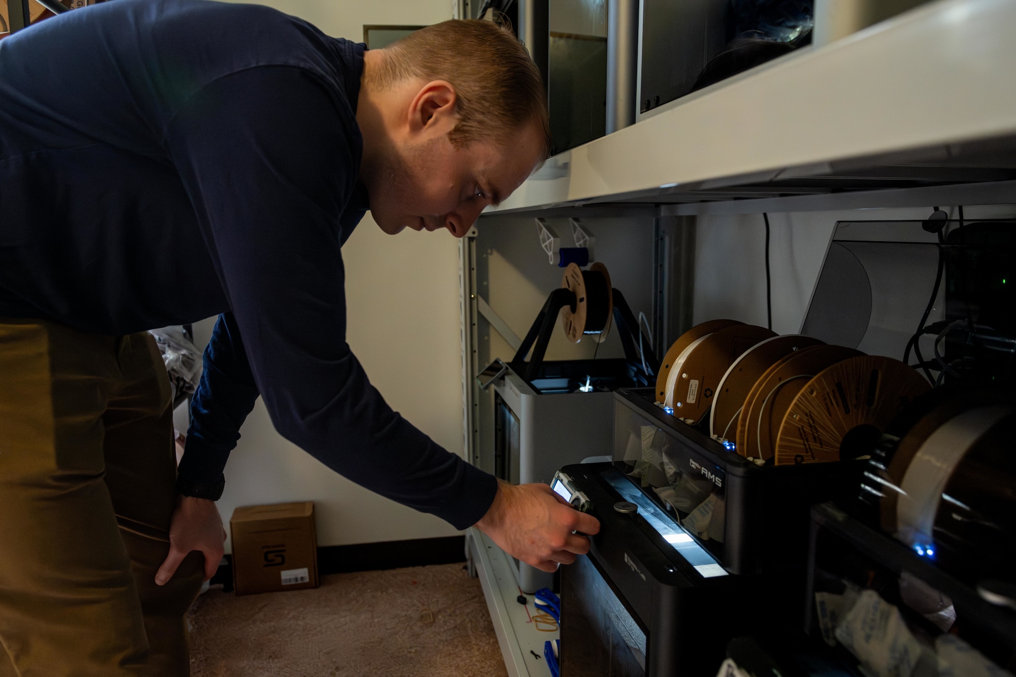 U.S. Air Force 1st Lt. Isaac Loring, lead Project Arc engineer assigned to the Innovation Lab, checks on the progress of 3D-printed training aids.