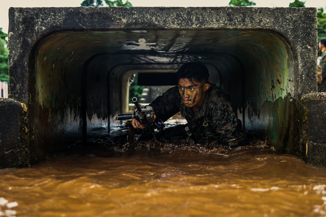 U.S. Marine Corps Cpl. Justin Caoile, a field artillery cannoneer with Kilo Battery, 3rd Battalion, 11th Marine Regiment, Marine Rotational Force – Darwin 25.3, treads through a low tunnel during jungle warfare training at the Combat Training Centre in Tully, Australia, June 18, 2025.