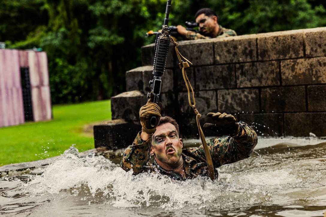 U.S. Navy Petty Officer Second Class Kahner Muhlithaler, a corpsman with Kilo Battery, 3rd Battalion, 11th Marine Regiment, Marine Rotational Force – Darwin 25.3, jumps into a pit of water during jungle warfare training at the Combat Training Centre in Tully, Australia, June 18, 2025.