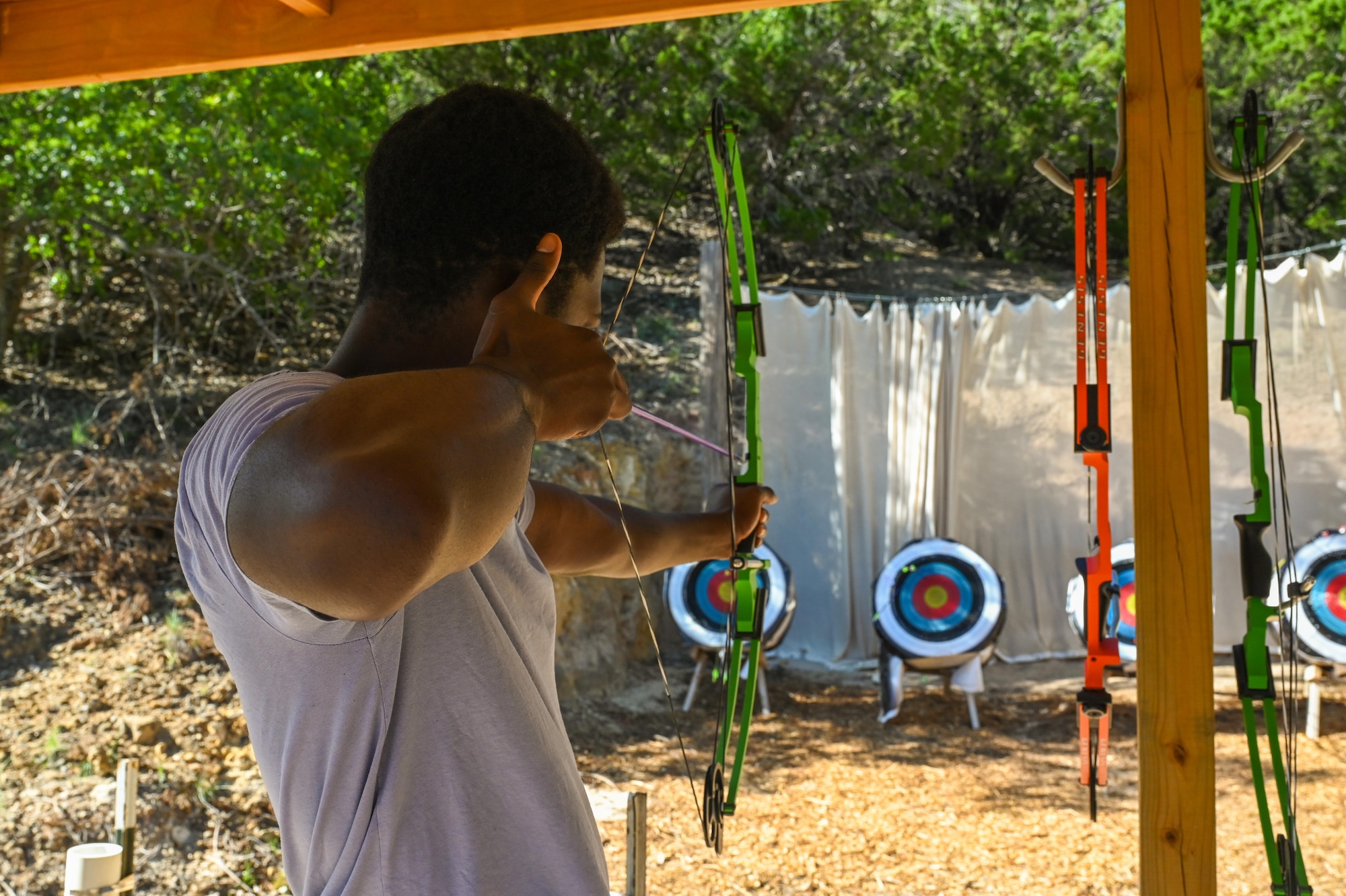 U.S. Air Force Airman 1st Class Ciance Jackson, 9th Bomber Generation Squadron avionics apprentice, aims a bow and arrow at a target during a resiliency retreat at Camp Butman, Texas, June 21, 2025. Airmen from Dyess Air Force Base participated in recreational activities during the weekend retreat, hosted by the Dyess AFB Chapel, to reinforce spiritual resiliency. (U.S. Air Force photo by Airman 1st Class Adrien Tran)