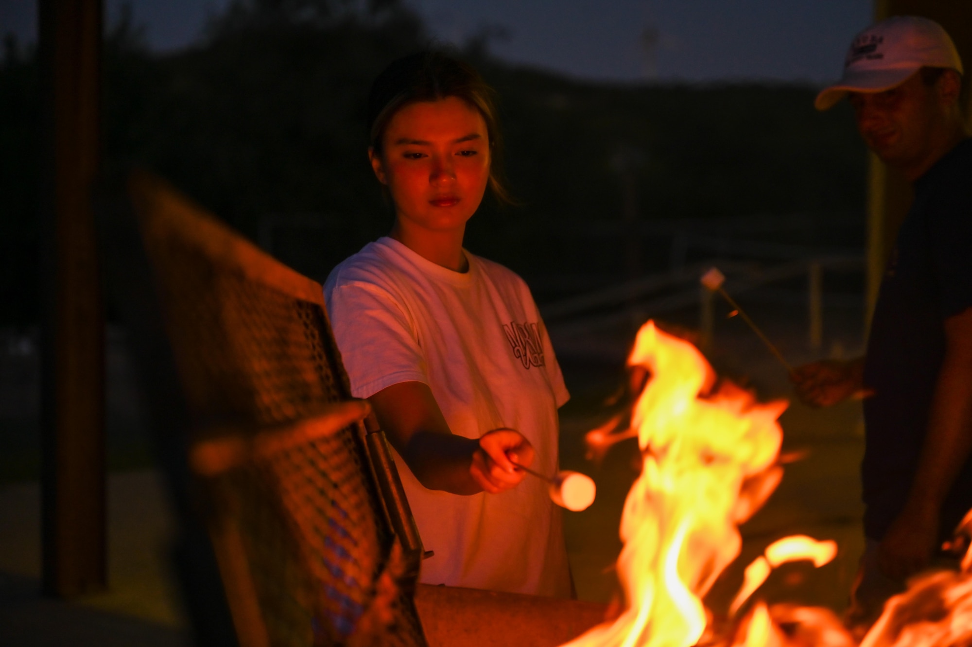 U.S. Air Force Airman 1st Class Angelina Vachon, 7th Force Support Squadron retention technician, roasts a marshmallow during a resiliency retreat at Camp Butman, Texas, June 21, 2025. The Dyess Chapel hosted the event, which helped Airmen channel their spiritual strengths and focused on physical, mental and social pillars of resiliency. (U.S. Air Force photo by Airman 1st Class Adrien Tran)