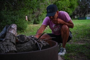U.S. Air Force Chaplain (Capt.) Jose Castro Cubero prepares for a bonfire during a resiliency retreat at Camp Butman, Texas, June 21, 2025. The Dyess Chapel sponsored the three-day retreat, open to Airmen of all ranks, as a way to refresh their mind, body and spirit while bonding with others in the outdoors. (U.S. Air Force photo by Airman 1st Class Adrien Tran)