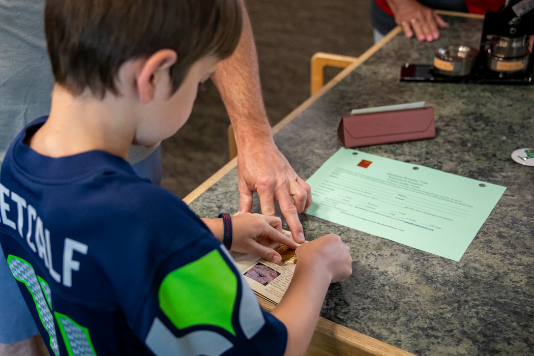 A young visitor to the U.S. Army Corps of Engineers’ Fort Peck Interpretive Center and Museum gets his final stamp to complete his Montana Dinosaur Trail passport, June 21, 2025, during the center’s 20th anniversary celebration in Fort Peck, Montana.