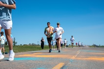 A group of Airmen assigned to the 891st Missile Security Forces squadron run in the Mental Health color run at Minot Air Force Base, North Dakota, June 30, 2025. The run encourages movement, connection and a healthy lifestyle.
