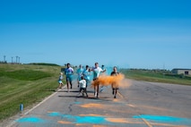 A group of Airmen assigned to the 891st Missile Security Forces squadron run in the Mental Health color run at Minot Air Force Base, North Dakota, June 30, 2025. The run encourages movement, connection and a healthy lifestyle.