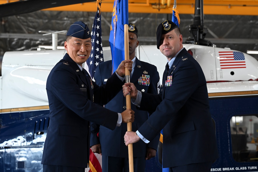 U.S. Air Force Col. June Oh, 316th Wing and installation commander, presents the guidon to U.S. Air Force Col. Joseph A. Bincarousky Sr., incoming commander for the 316th Security Forces Group, during the unit’s change of command ceremony at Joint Base Andrews, Md., July 3, 2025. The passing of the guidon symbolizes the official transfer of authority and responsibility.