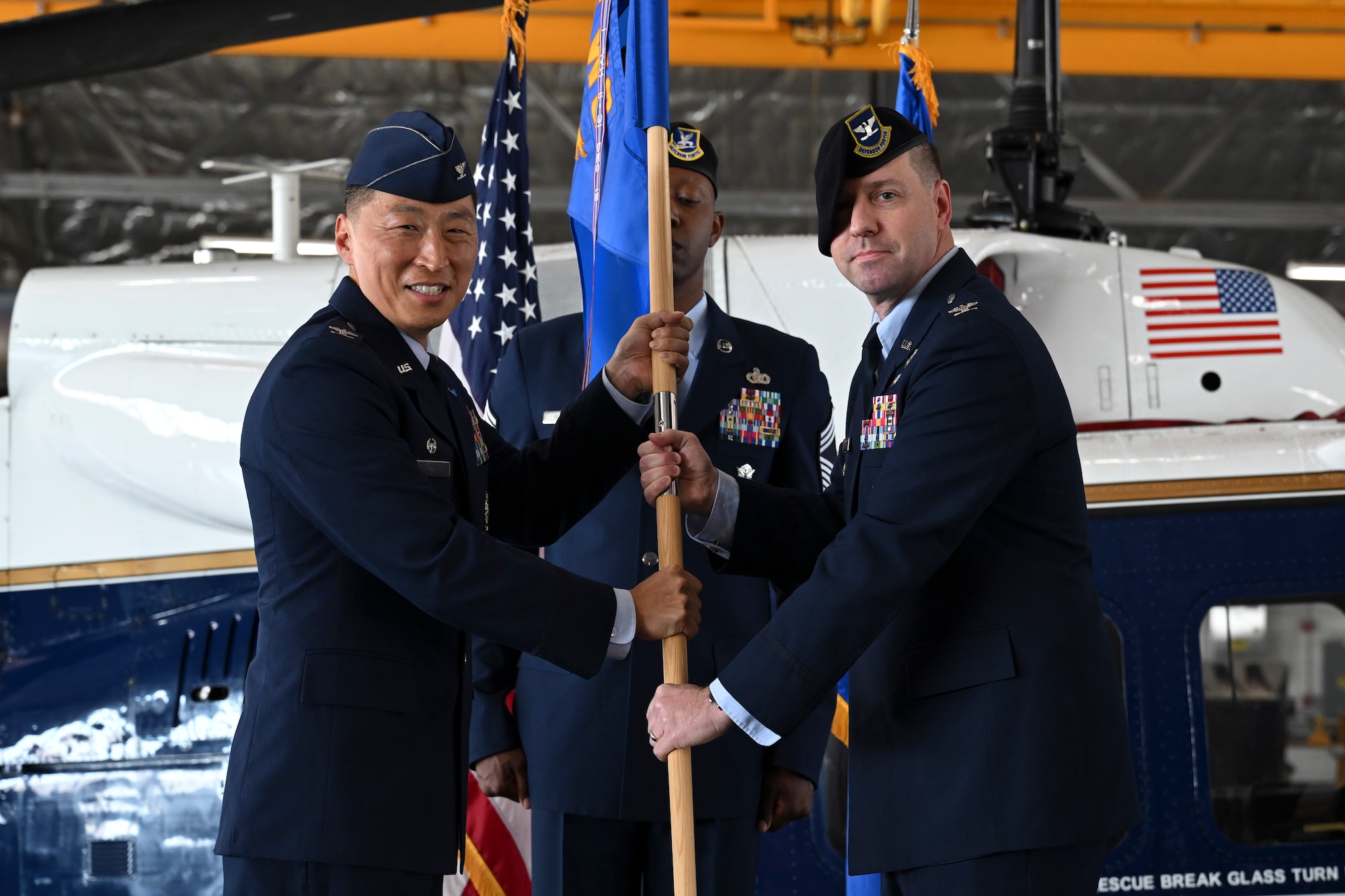 U.S. Air Force Col. June Oh, 316th Wing and installation commander, presents the guidon to U.S. Air Force Col. Joseph A. Bincarousky Sr., incoming commander for the 316th Security Forces Group, during the unit’s change of command ceremony at Joint Base Andrews, Md., July 3, 2025. The passing of the guidon symbolizes the official transfer of authority and responsibility.