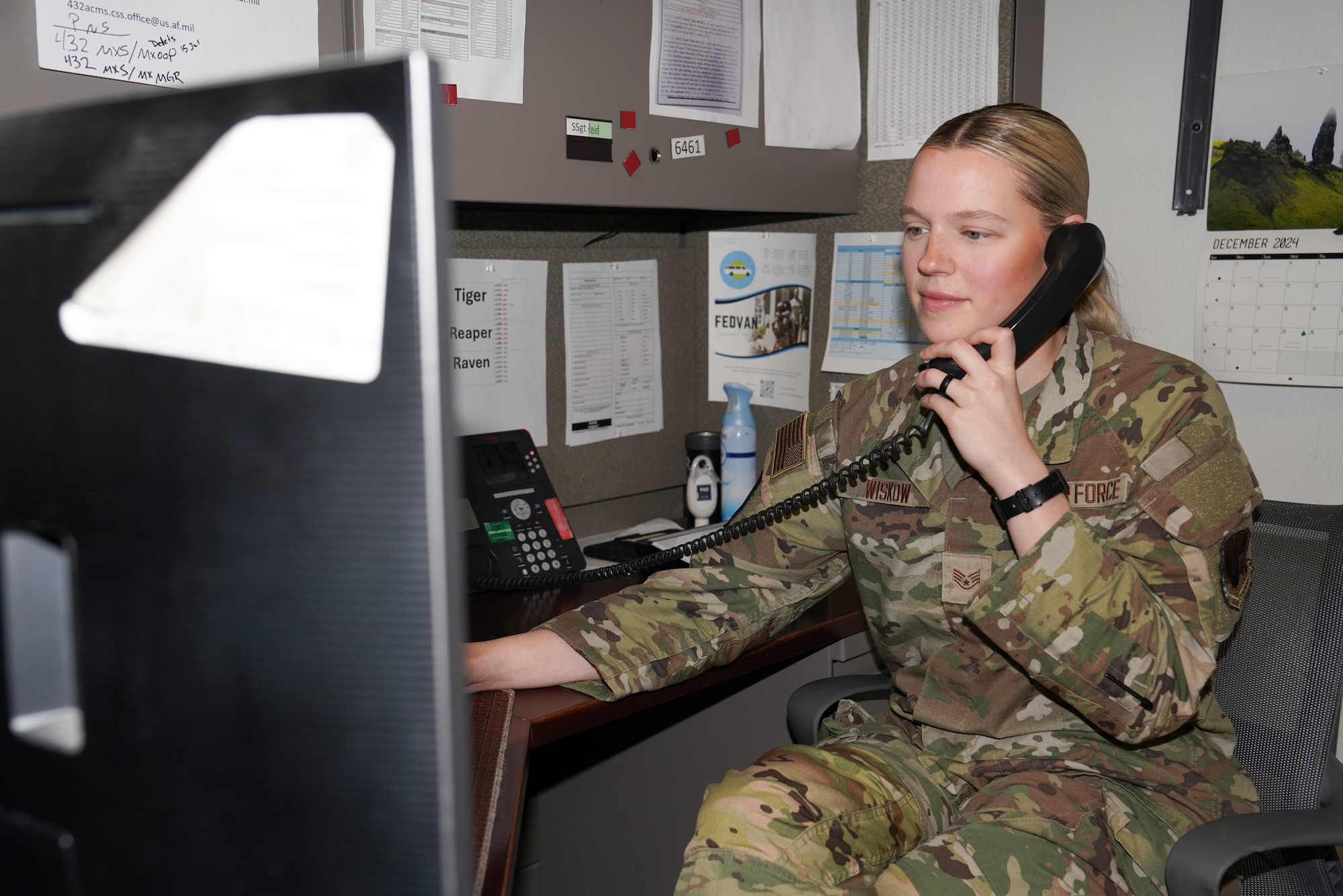 A woman in a military uniform answers a phone call.