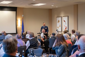 Col. Martinez stands before members of the 307th Bombardment Group during their reunion dinner to offer a speech.
