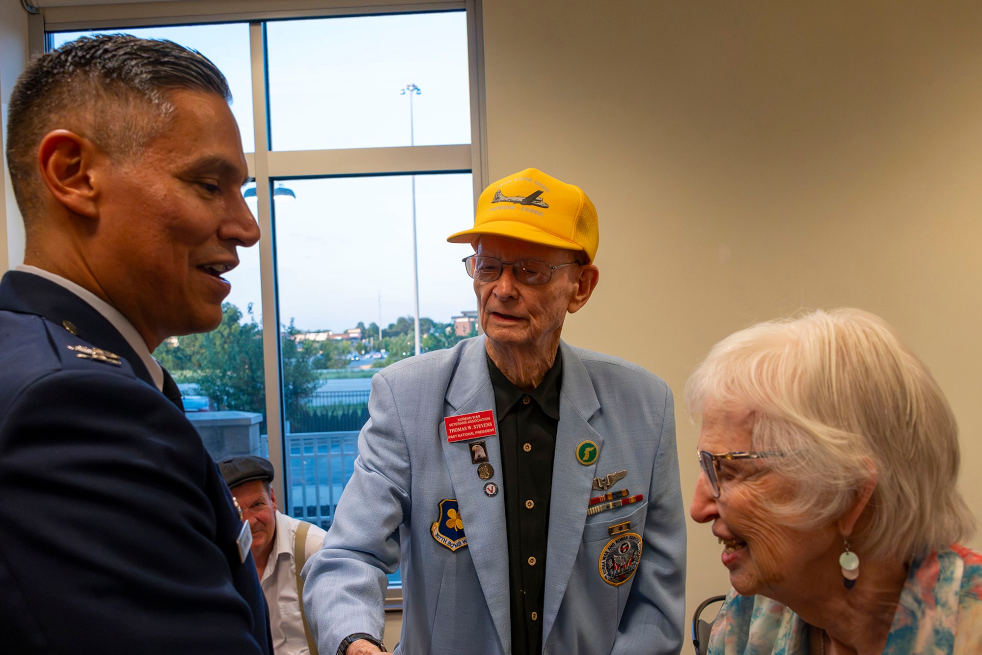Col. Martinez shakes the hand of a veteran while smiling/