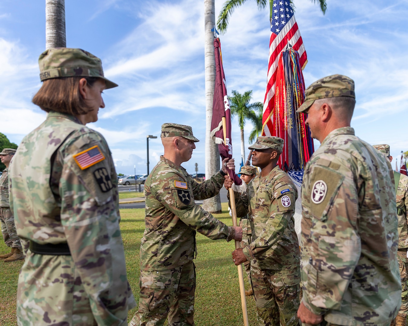 U.S. Army Col. William Bimson (center left), incoming commander, passes the unit colors to U.S. Army Command Sgt. Maj. Omar J. Bond, during the change of command ceremony for Tripler Army Medical Center, June 30, 2025.