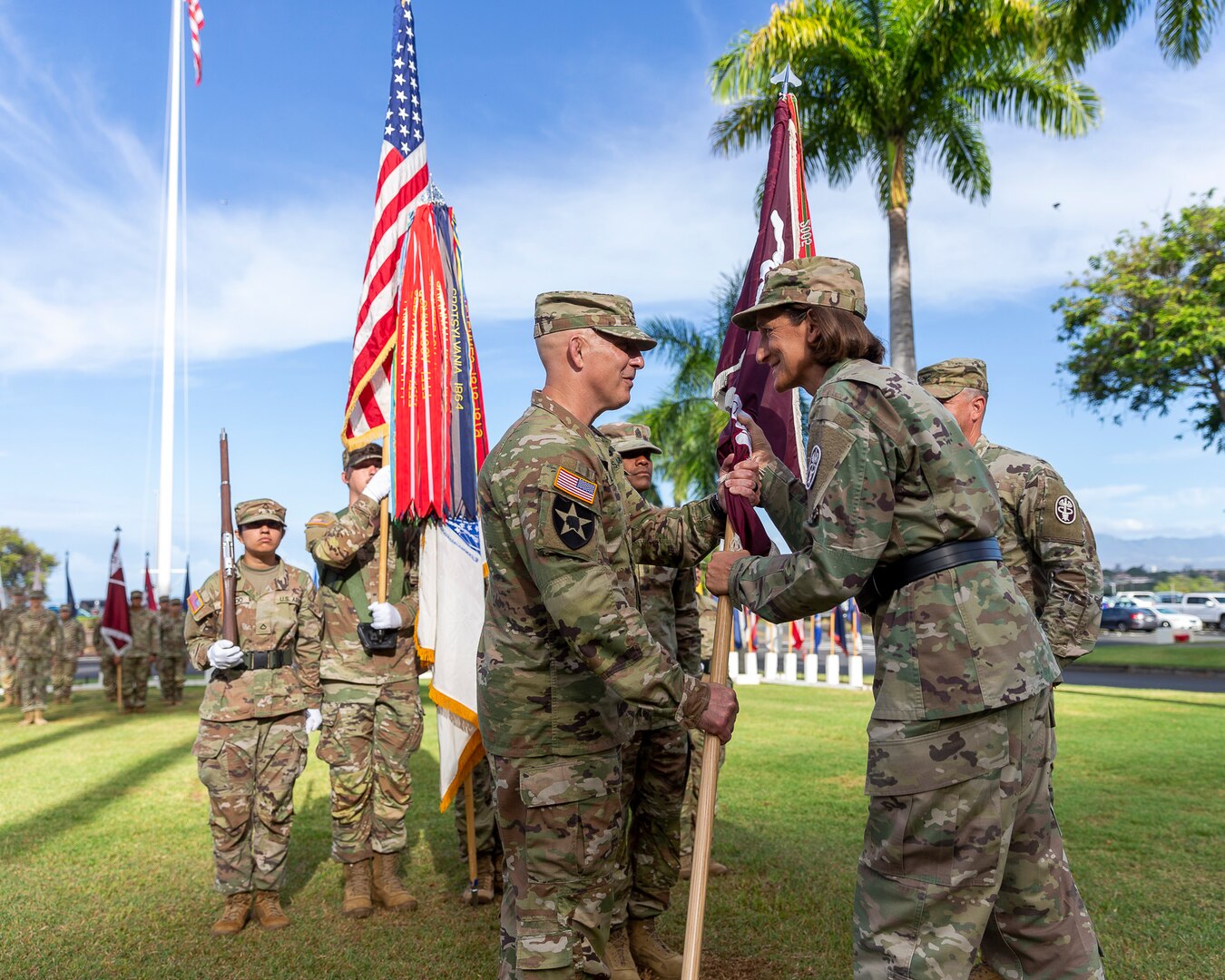 U.S. Army Brig. Gen. Deydre Teyhen (right), commanding general, Medical Readiness Command, Pacific, and director, Defense Health Network Indo-Pacific, passes the unit colors to U.S. Army Col. William Bimson, incoming commander, during the change of command ceremony for Tripler Army Medical Center, Hawaii, June 30, 2025.