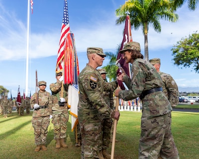 U.S. Army Brig. Gen. Deydre Teyhen (right), commanding general, Medical Readiness Command, Pacific, and director, Defense Health Network Indo-Pacific, passes the unit colors to U.S. Army Col. William Bimson, incoming commander, during the change of command ceremony for Tripler Army Medical Center, Hawaii, June 30, 2025.