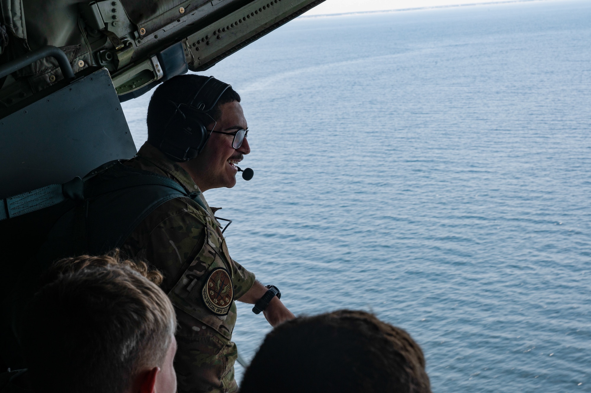A U.S. Air Force loadmaster assigned to the 1st Special Operations Wing sits on the ramp of a 1st SOW MC-130J Commando II with Air Force Junior ROTC cadets during an orientation flight near Hurlburt Field, Florida, June 25, 2025.