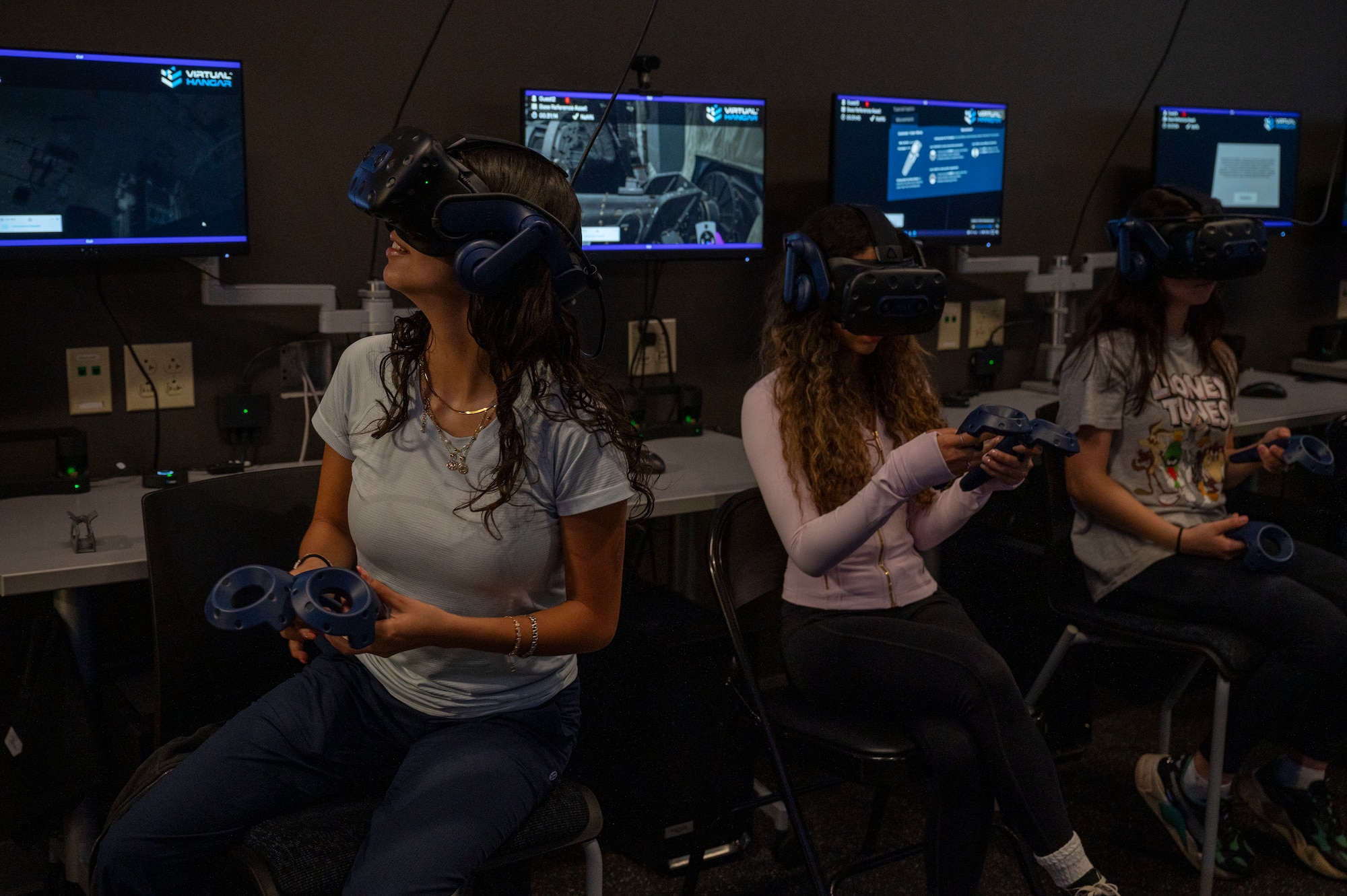 Students from Fort Walton Beach High School operate a virtual reality headset to perform simulated maintenance duties during a tour at Hurlburt Field, Florida, May 8, 2025.