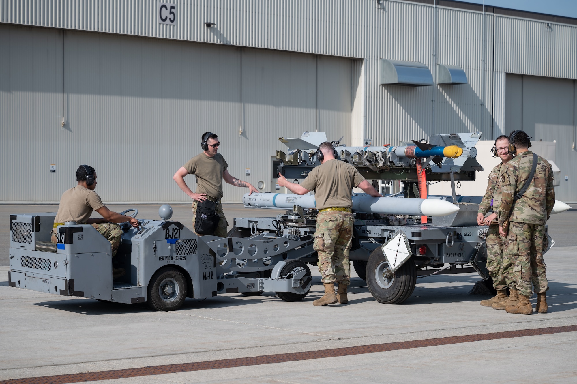 U.S. Air Force Airmen from the 18th Fighter Generation Squadron, transport an inert AIM-120 Advanced Medium Range Air-to-Air Missile during the second quarter load competition at Eielson Air Force Base, Alaska, July 3, 2025.