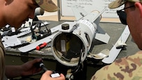 Two Airmen discuss their plan for a munitions build.