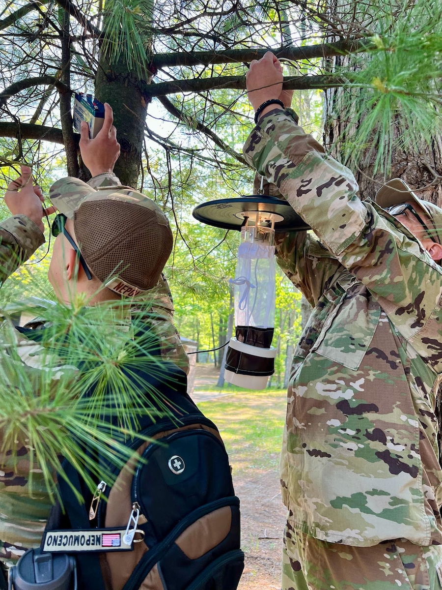 Tech. Sgt. Jazzmin Tristan, a Public Health technician with the 168th Wing, along with other Air National Guard counterparts, set a light trap to monitor mosquito activity during field training at Alpena Combat Readiness Training Center, Michigan