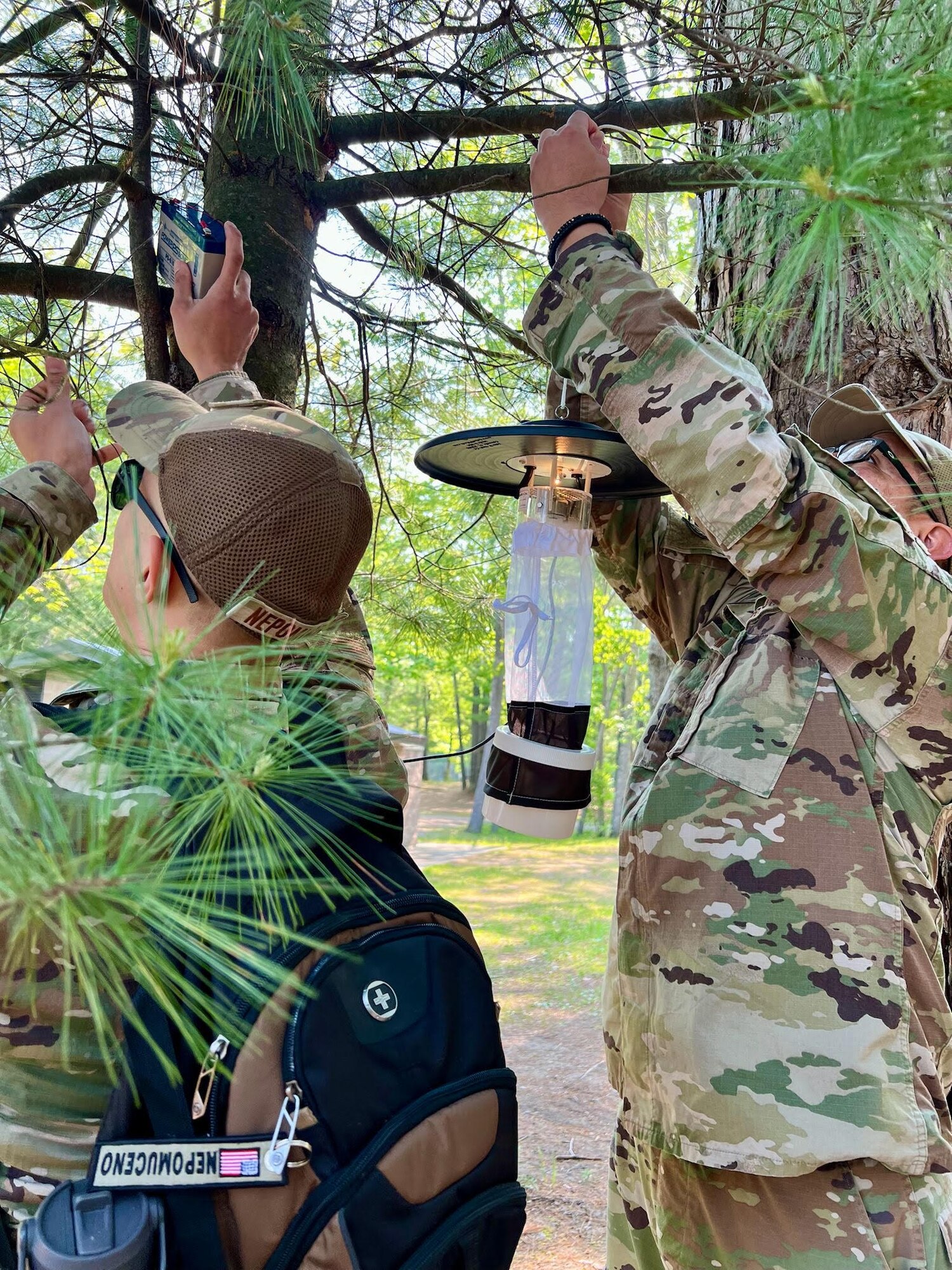 Tech. Sgt. Jazzmin Tristan, a Public Health technician with the 168th Wing, along with other Air National Guard counterparts, set a light trap to monitor mosquito activity during field training at Alpena Combat Readiness Training Center, Michigan