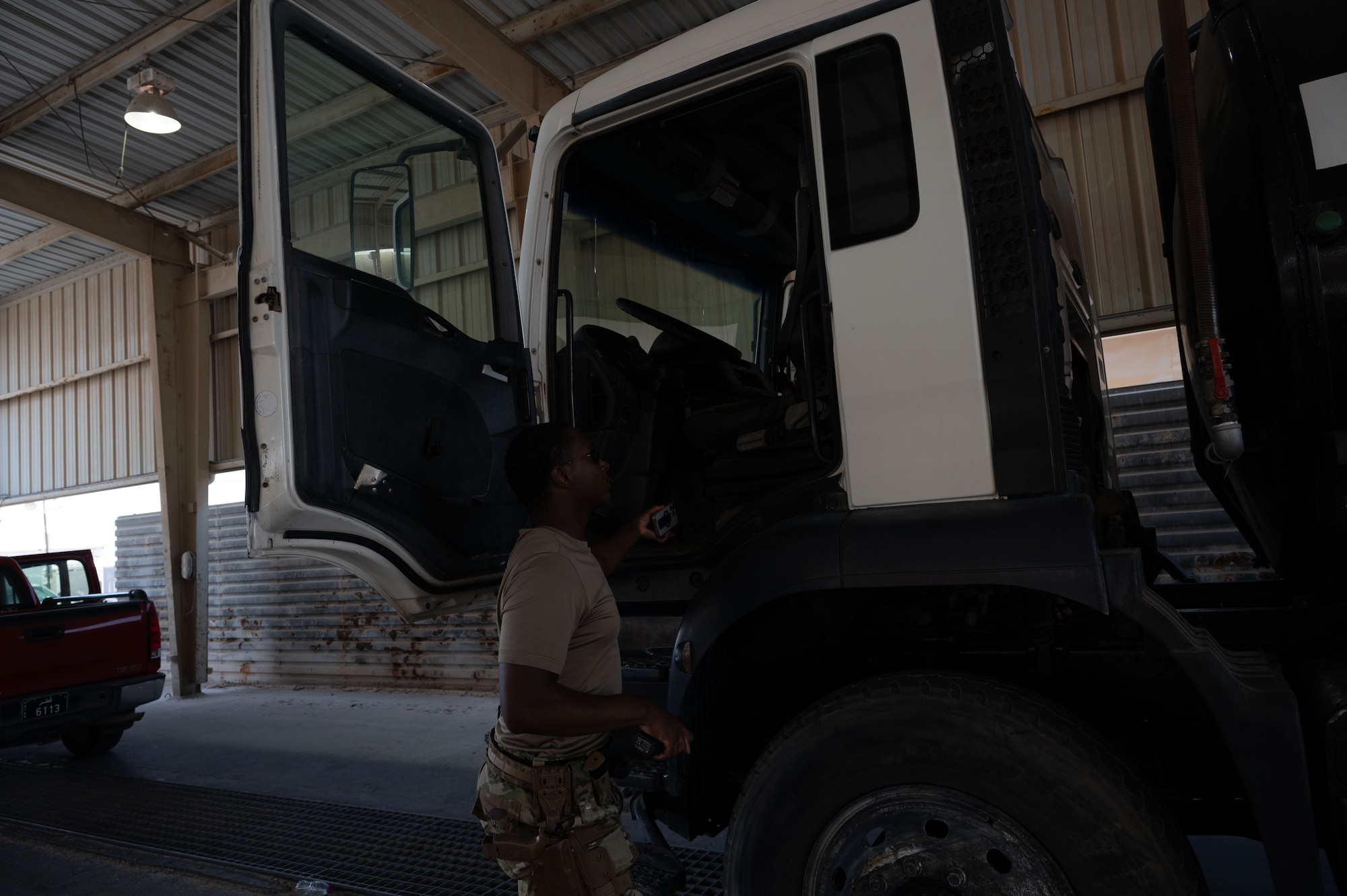 U.S. Air Force Senior Airman William Butler, 379th Expeditionary Security Forces Squadron entry controller, performs a vehicle search within the U.S. Central Command area of responsibility, June 17, 2025. The 379 ESFS is responsible for the security of personnel and the protection of resources, ensuring the base's operations can continue without interruption. (U.S. Air Force Photo by Senior Airman Dieondiere Jefferies)