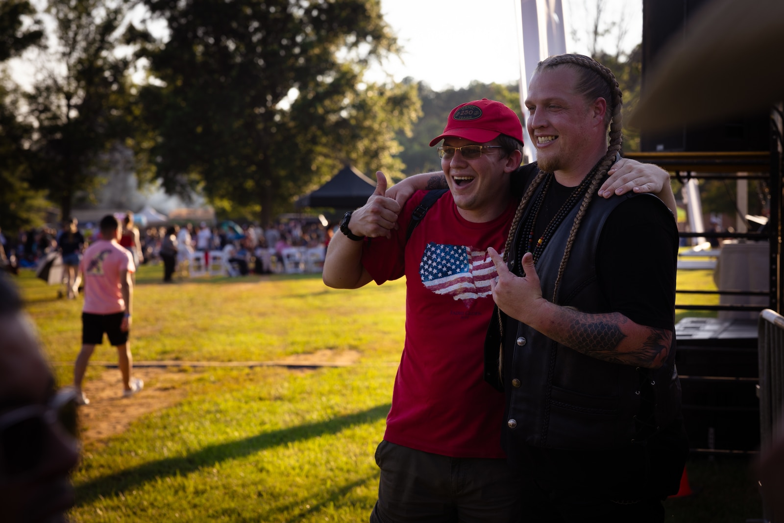 Michael Huntley, right, an American blues rock singer-songwriter and winner of The Voice season 24, poses for a photo with a fan during Marine Corps Base Quantico’s Fourth of July celebration at Lejeune Field, MCB Quantico, Virginia, July 3, 2025. The event hosted a multitude of outdoor activities for families, friends and service members to include; bouncy house obstacle courses, a rock climbing wall, and games such as corn hole. The celebration featured a live performance from artist Huntley and ended in a firework show. (U.S. Marine Corps photo by Cpl. Darien Wright)