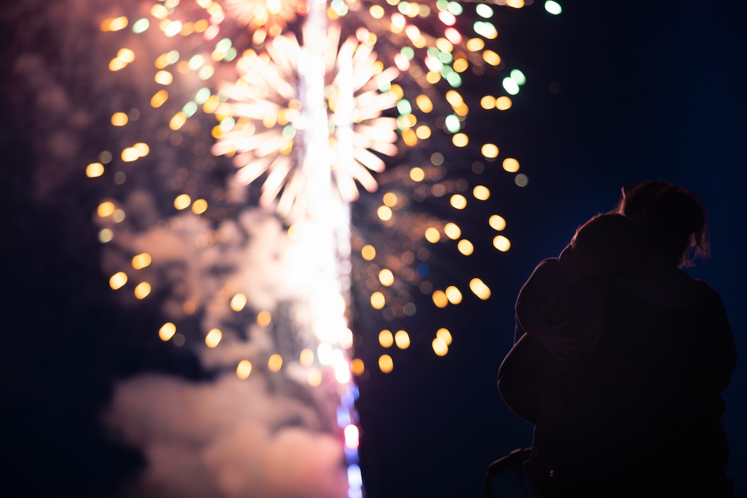 A family watches a firework show during Marine Corps Base Quantico’s Fourth of July celebration at Lejeune Field, MCB Quantico, Virginia, July 3, 2025. The event hosted a multitude of outdoor activities for families, friends and service members to include; bouncy house obstacle courses, a rock climbing wall, and games such as corn hole. The celebration featured a live performance from artist Huntley and ended in a firework show. (U.S. Marine Corps photo by Cpl. Darien Wright)