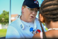Wendy Thompson gives a glitter temporary tattoo to Athena Toussaint at Freedom Fest at JBAB on July 4, 2025.