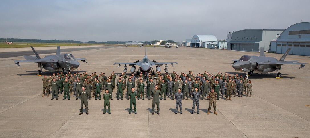 U.S. Marines and Sailors with Marine Fighter Attack Squadron (VMFA) 214, Marine Aircraft Group 12, 1st Marine Aircraft Wing and Japan Air Self-Defense Force members pose for a group photo during a deployment for training at Misawa Air Base, Japan, June 20, 2025. VMFA-214, an F-35B squadron from Marine Corps Air Station Yuma, Arizona, deployed to augment MAG-12, 1st MAW under the Unit Deployment Program, which provides U.S.-based units with operational experience in the Indo-Pacific. VMFA-214, an F-35B squadron from Marine Corps Air Station Yuma, Arizona, deployed to augment MAG-12, 1st MAW under the Unit Deployment Program, which provides U.S.-based units with operational experience in the Indo-Pacific. VMFA-214 conducted joint exercises that integrated the expertise of joint tactical air controllers at Draughon Range, Misawa Air Base. (U.S. Marine Corps photo by Cpl. Colin Thibault)