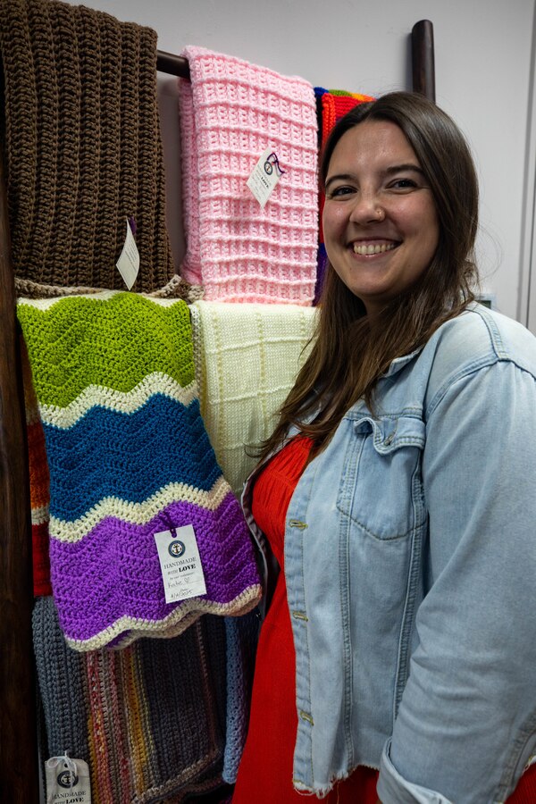 Katie Mintz, U.S. Navy Ombudsman with Strike Fighter Squadron (VFA) 102, Carrier Air Wing (CVW) 5, holds a handmade blanket she created for the Navy-Marine Corps Relief Society at Marine Corps Air Station Iwakuni, Japan, June 6, 2025. Mintz was chosen as the recipient of the 2024 Dorothy Flatley award for exceptional support to Sailors, Marines, and their families. (U.S. Marine Corps photo by Sgt. Isaac Orozco)