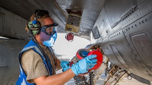 A woman disconnects a fuel hose.