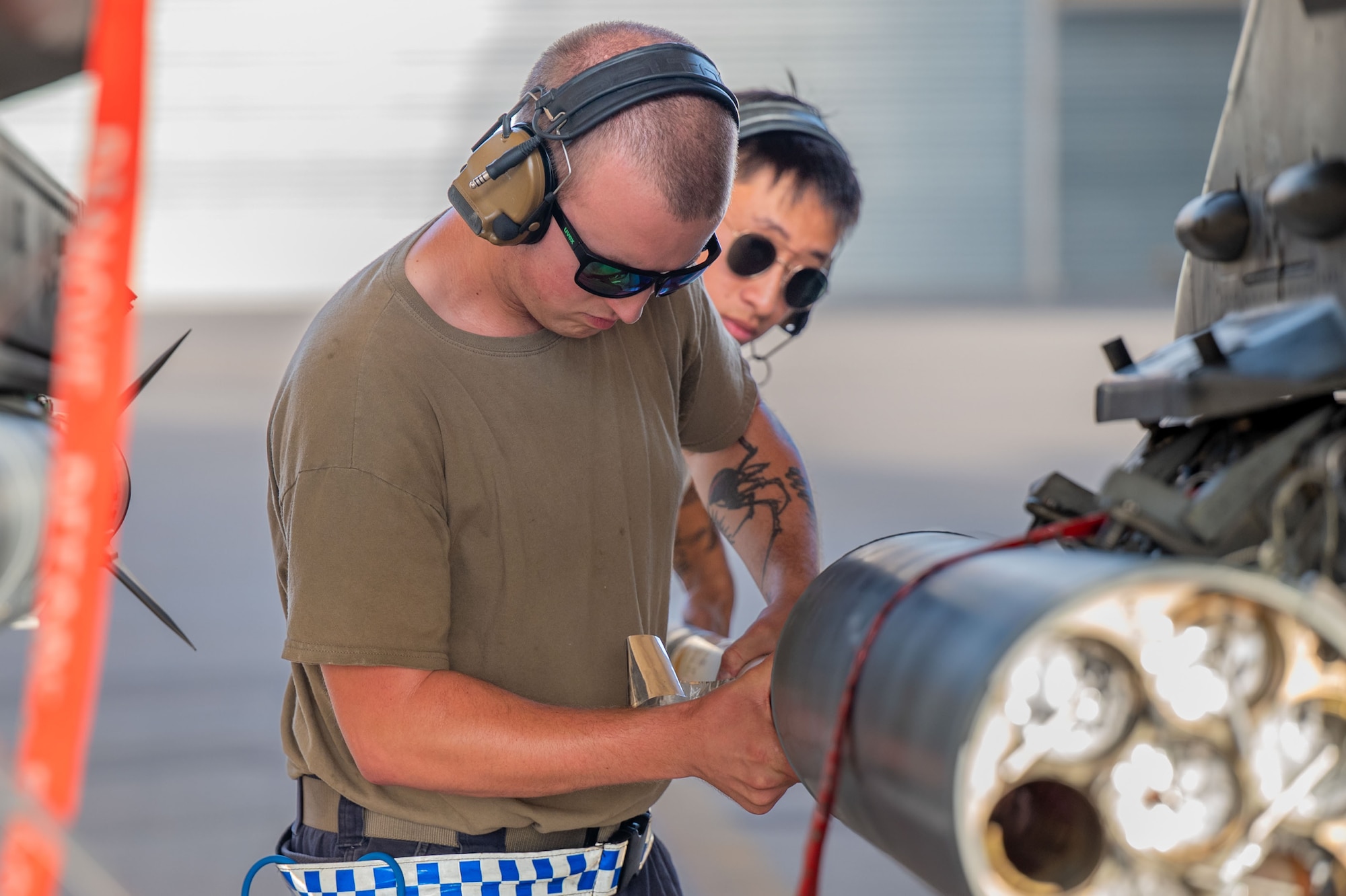 Two men load a rocket.