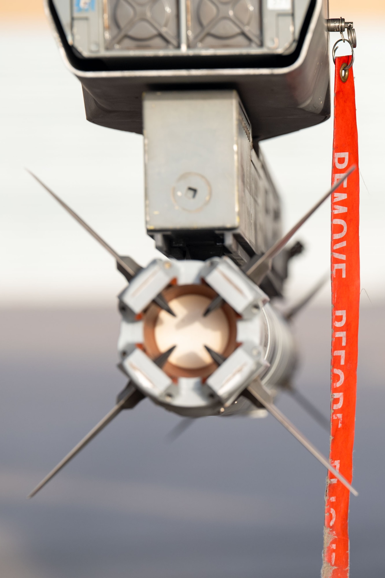 A safety pin hangs from an AIM-9X missile