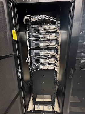 Photo of network cables in a distribution panel inside of a rack.