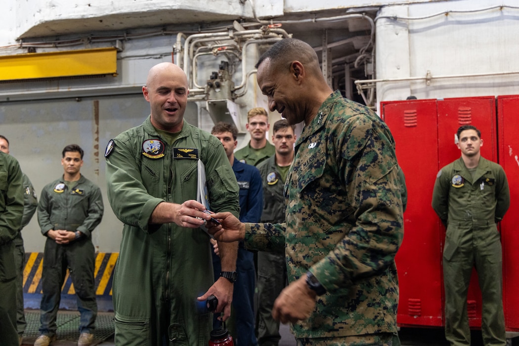 U.S. Marine Corps Lt. Col. Terry Carter Jr., Commanding Officer, Marine Medium Tiltrotor Squadron 263 (Reinforced), 22nd Marine Expeditionary Unit presents Lieutenant General Calvert Worth Jr., Commanding General, II Marine Expeditionary Force, with a VMM-263 (REIN) unit patch during his visit aboard the Wasp-class amphibious assault ship USS Iwo Jima (LHD 7), during Composite Training Unit Exercise while underway in the Atlantic Ocean, June 28, 2025. During COMPTUEX, the IWO ARG and 22nd MEU(SOC), refine tactics, techniques, and procedures to execute warfighting functions that enhance operational readiness and lethality as a unified IWOARG/22MEU(SOC) team. (U.S. Marine Corps photo by Cpl. Sharon Errisuriz)