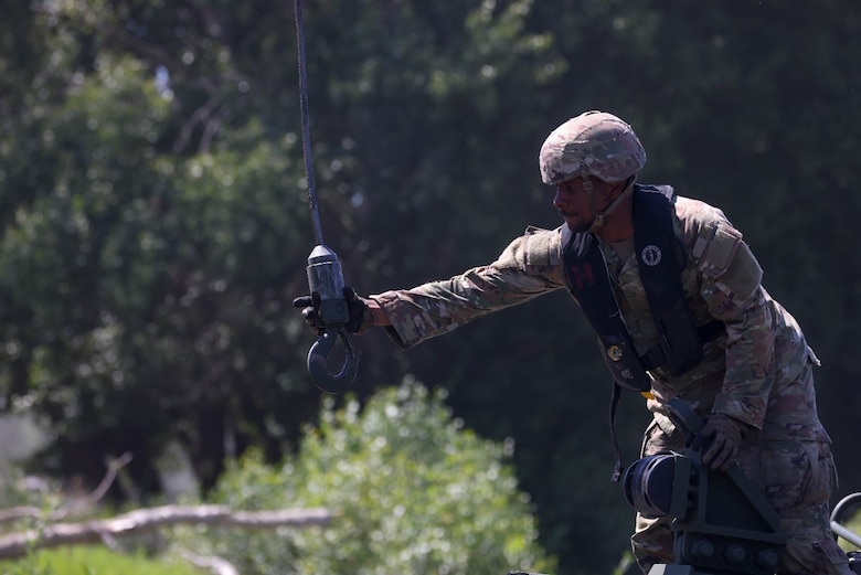 U.S. Army Sgt. Jalen Brown, 12C Boat Crew Member assigned to the 809th Multi-Role Bridge Company, 7th Engineer Brigade, 21st Theater Sustainment Command, grabs a hook to secure and lift the M30 Bridge Erection Boat out of the water during wet gap crossing rehearsals for Saber Guardian 25 on June 8, 2025. Exercises like this allow the U.S. Army to operate at new ports while also rehearsing the deployment and integration of U.S. military combat equipment throughout Europe, ensuring that the U.S. Army is ready at all times to support and defend NATO allies and partner forces across all domains.