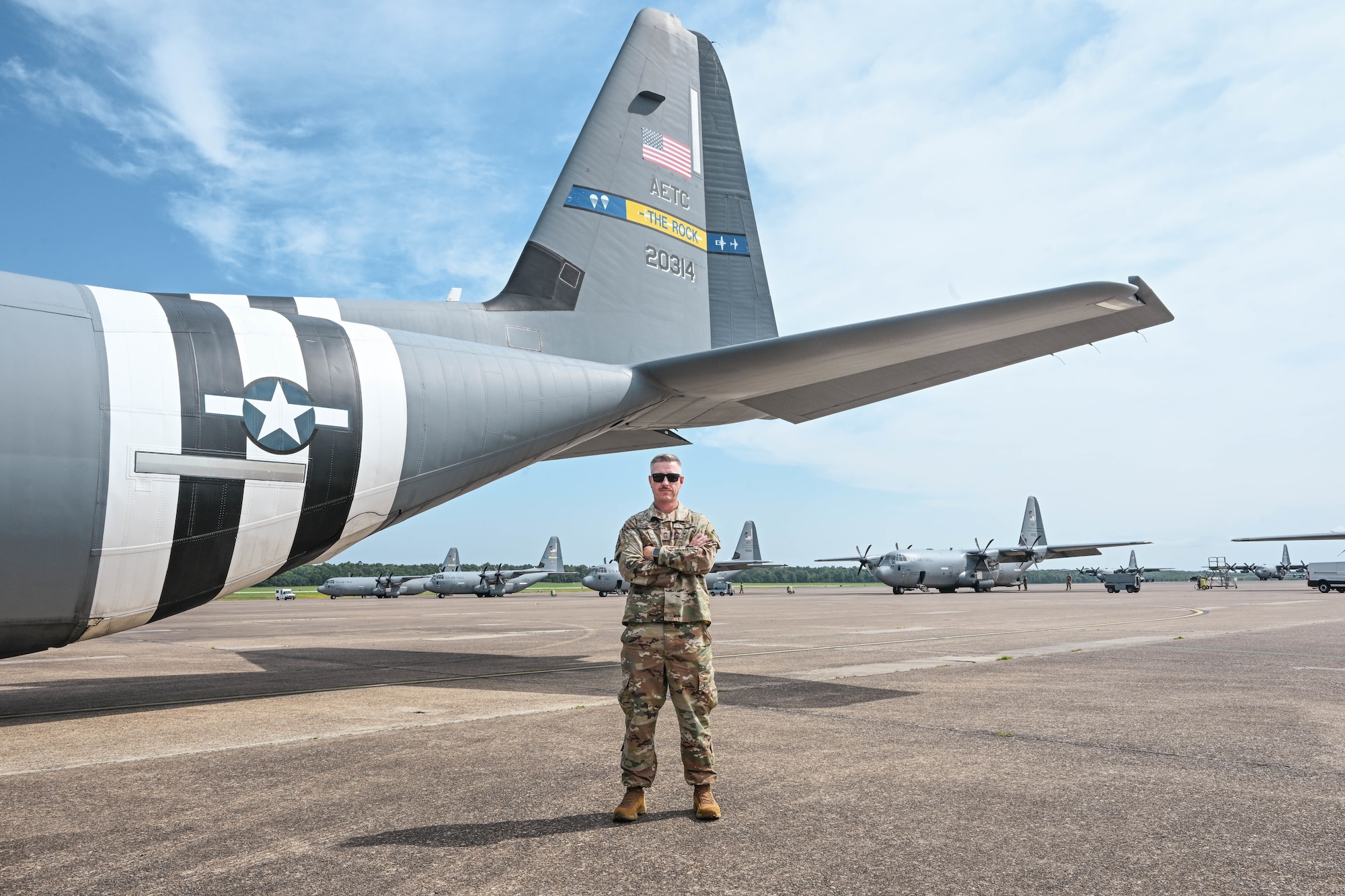 A man in uniform stands beside an aircraft.