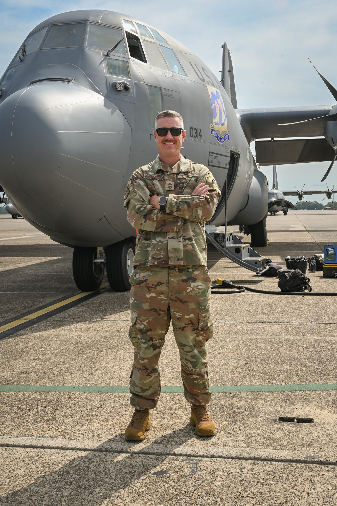 A man in uniform stands in front of a plane.
