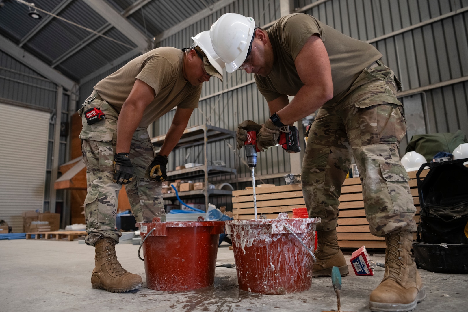 From left, U.S. Air Force Tech. Sgt. Luis Martin, and Staff Sgt. Juan Arbelo, both water and fuels systems specialists assigned to the 156th Civil Engineer Squadron, Puerto Rico Air National Guard, prepare the tiles grout for a bathroom floor tiles installation during a Deployment for Training (DFT) at Aviano Air Base, Italy, June 24, 2025.