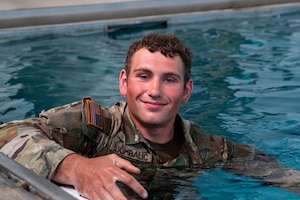 FORT RILEY, Kan. – Soldiers participate in a water survival test during the Best Squad Competition at Fort Riley on May 30, 2025. The assessment included swimming while holding an M4 rifle, along with exercises such as pushups, overhead claps and lunges performed while maintaining control of the weapon. The event tested participants’ physical readiness, mental toughness and ability to operate in challenging aquatic conditions.(U.S. Army photos by Spc. Autumn Johnson)