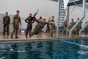 FORT RILEY, Kan. – Soldiers participate in a water survival test during the Best Squad Competition at Fort Riley on May 30, 2025. The assessment included swimming while holding an M4 rifle, along with exercises such as pushups, overhead claps and lunges performed while maintaining control of the weapon. The event tested participants’ physical readiness, mental toughness and ability to operate in challenging aquatic conditions.(U.S. Army photos by Spc. Autumn Johnson)