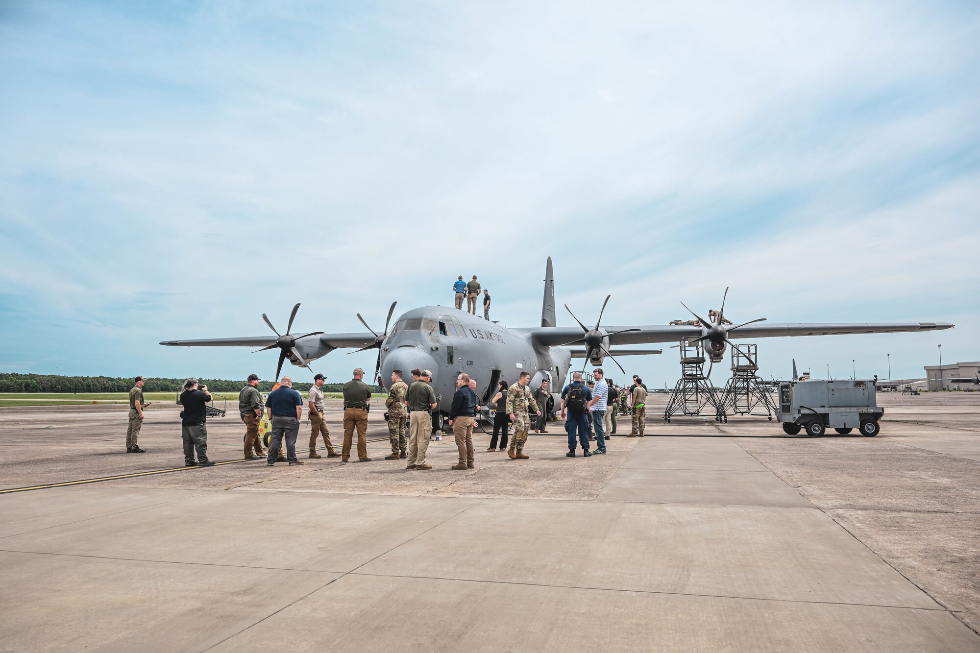 Men and women stand around an aircraft.
