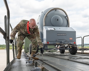 A large oxygen tank is loaded on to an off loading vehicle.