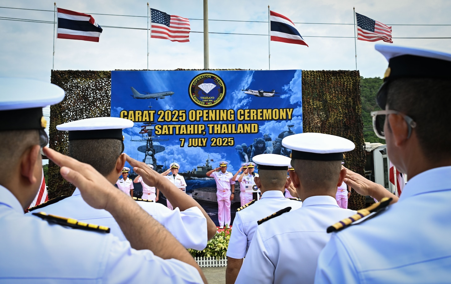 U.S. Navy and Royal Thai Navy leaders salute a formation of U.S. and Thai service members during the opening ceremony of exercise Cooperation Afloat Readiness and Training (CARAT) at Sattahip Naval Base, Thailand, July 7, 2025. The 31st iteration of CARAT, a multinational exercise series, is designed to enhance the U.S. and partner navies' abilities to operate together in response to traditional and non-traditional maritime security challenges in the Indo-Pacific region. (U.S. Air Force photo by Staff Sgt. Destani Hill)