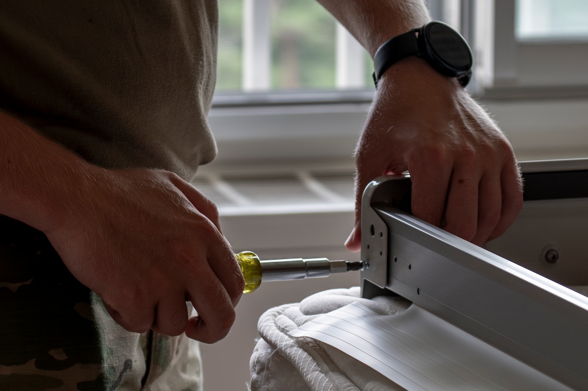 A U.S. Air Force Airman assigned to the 35th Fighter Wing assembles a portable air conditioning unit frame to be installed in a contingency dormitory for Exercise Resolute Force Pacific (REFORPAC) at Misawa Air Base, Japan, July 2, 2025. These enhancements allow the installation to flex and scale in support of joint, coalition and contingency operations during REFORPAC. (U.S. Air Force photo by Senior Airman Brittany Russell)