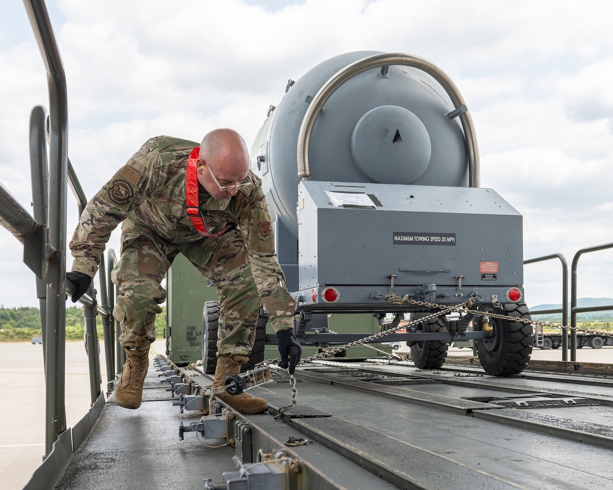 A large oxygen tank is loaded on to an off loading vehicle.