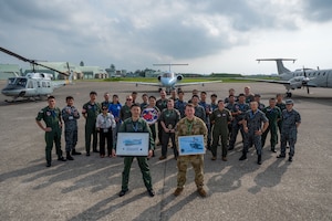 A group photo in front of three aircraft
