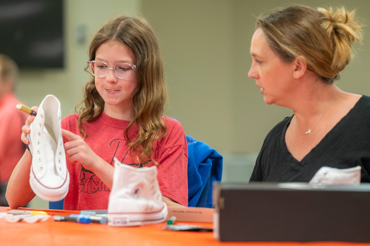 Gretchen Betten (right) and her daughter, Bethany, customize a pair of shoes during Operation Sole, at JBSA-Fort Sam Houston, Texas, June 14.